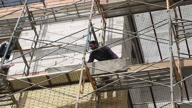 يستخدم العمال الطوب لتغطية واجهة مبنى قيد الإنشاء في العاصمة العراقية بغداد في 24 يناير 